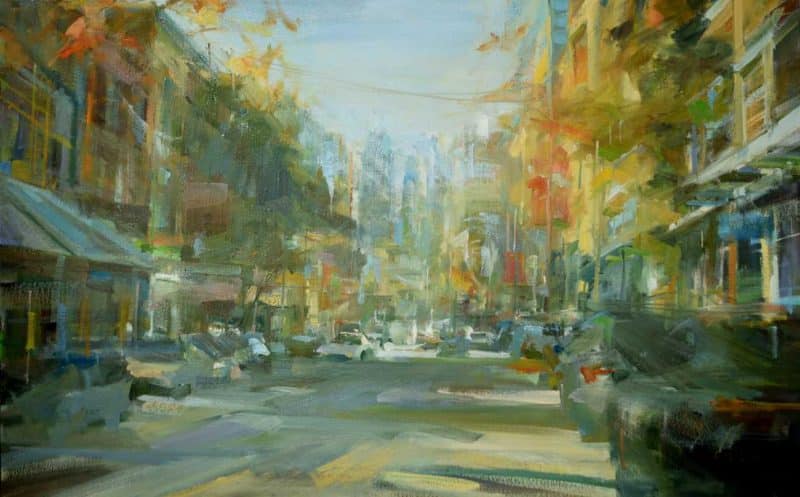 Original oil painting with Autumn Colours. The painting by Leanne Christie has brushwork that is energetic and the viewer is standing in the middle of the street looking west towards the highrises of downtown Vancouver. The street's trees and buildings are described with warm oranges, yellows and greens. Genre: Urban art, streetscape. Artist: Leanne M Christie. Location: East Georgia street, China Town, Vancouver. Medium: Oil on canvas.