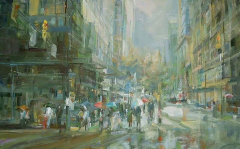 Streetscape painting. The original oil painting depicts a downtown street during the rain. There are the suggestions of people with umbrellas on the left of the painting. The colours are greys, orange and blues and the pallet is soft. The painting is atmospheric with the wetness of the grey morning in Vancouver